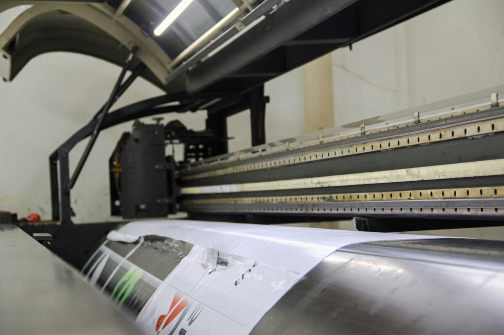 Wide-format printer running a roll of printed vinyl